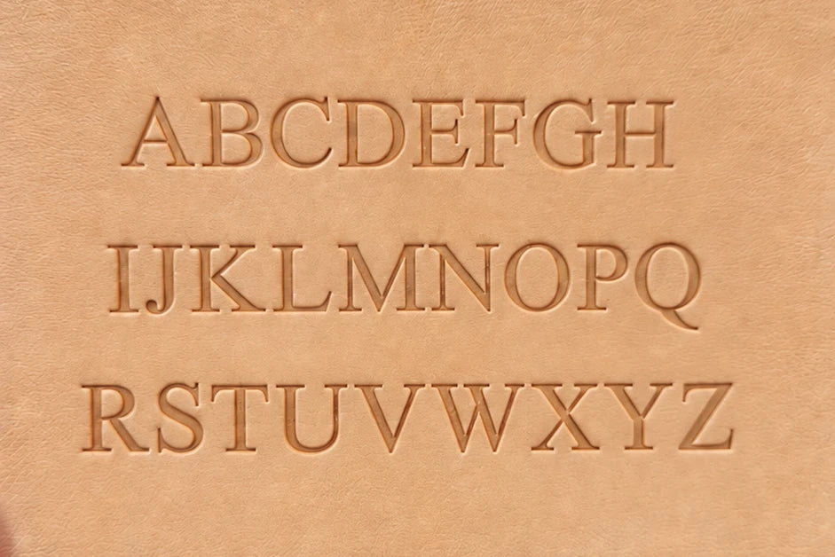 The alphabet, A to Z, embossed into tan leather.
